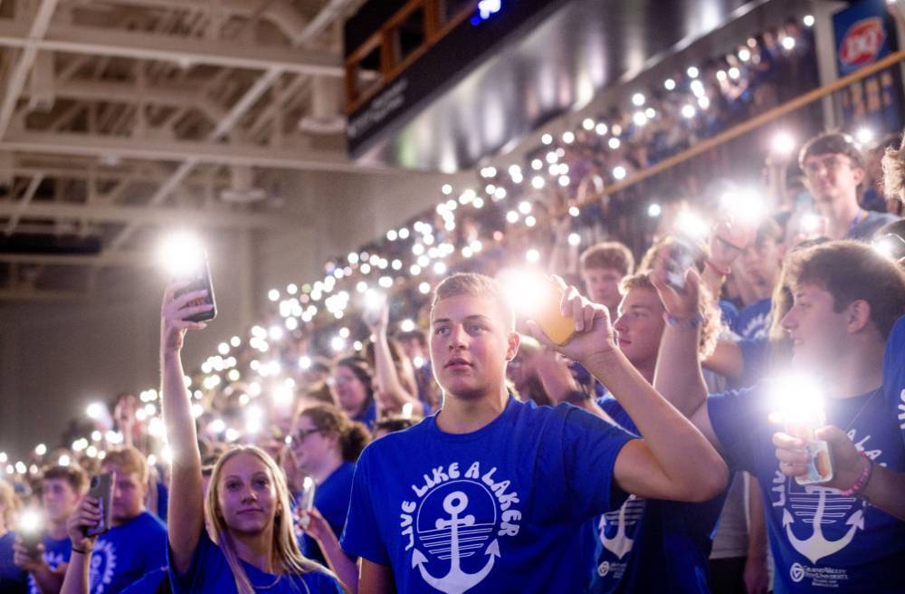 Students holding up cell phone lights during Convocation